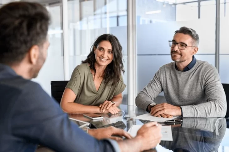 clients smiling at a meeting table with insurrection digital